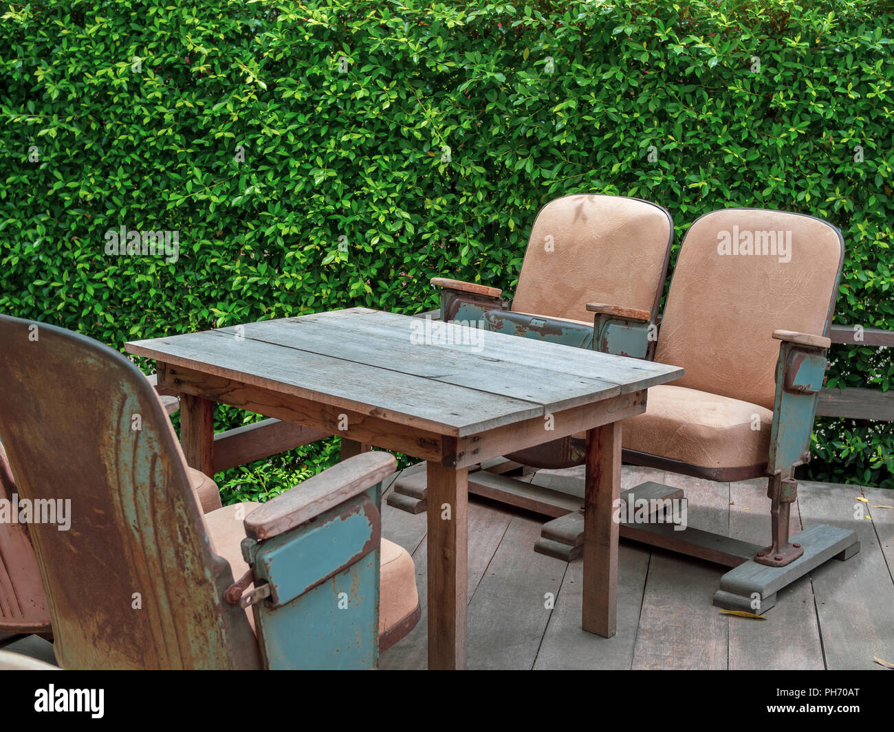 Vintage Theatre Seats With Wooden Table On Wooden Terrace On Green
