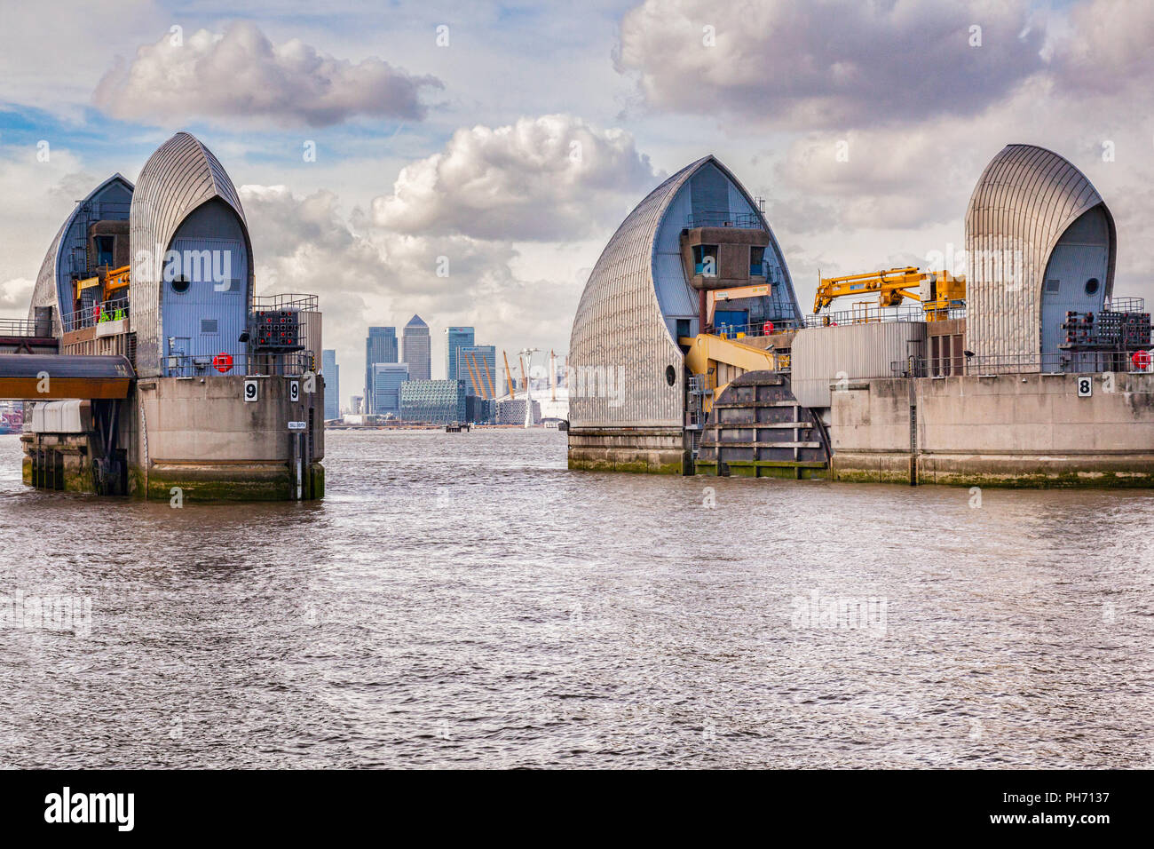Thames Barrier, London, with Canary Wharf and the Millennium Dome in the background. Stock Photo