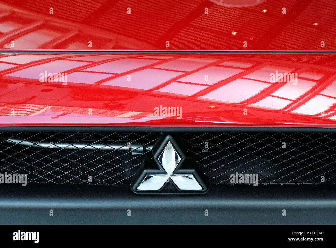 The logo of Mitsubishi Motors Corp. is shown on the front of a vehicle