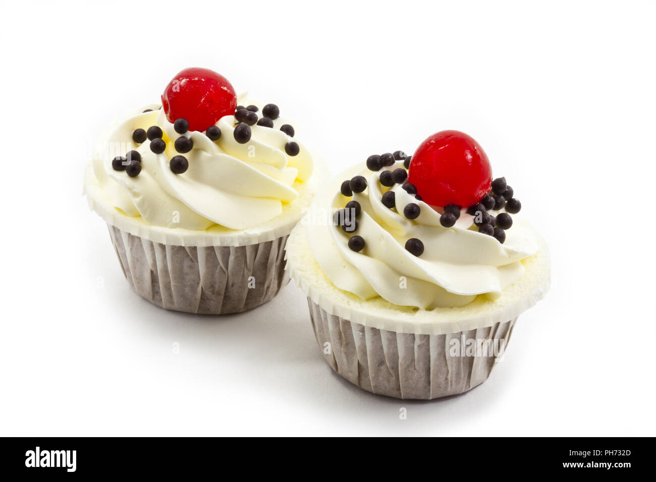 Cup cake garnished with white cream and cherry Stock Photo