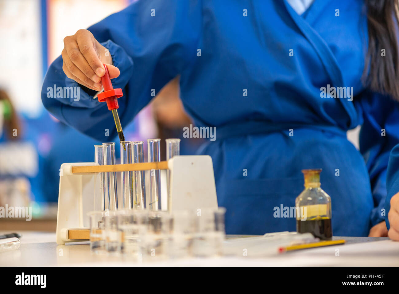 Coloured test tubes photographed in a school classroom during a science lesson and experiment. Stock Photo