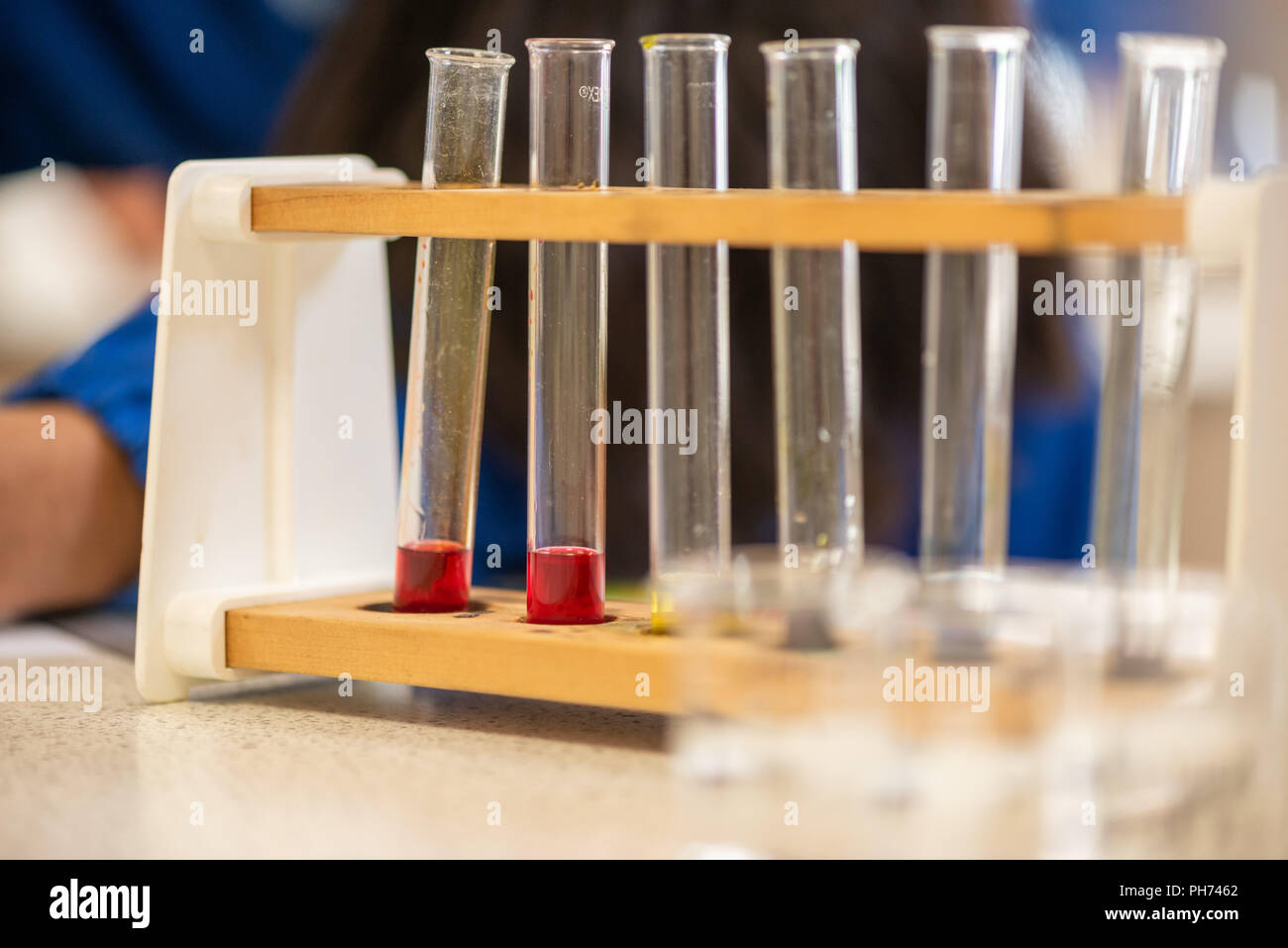 Coloured test tubes photographed in a school classroom during a science lesson and experiment. Stock Photo