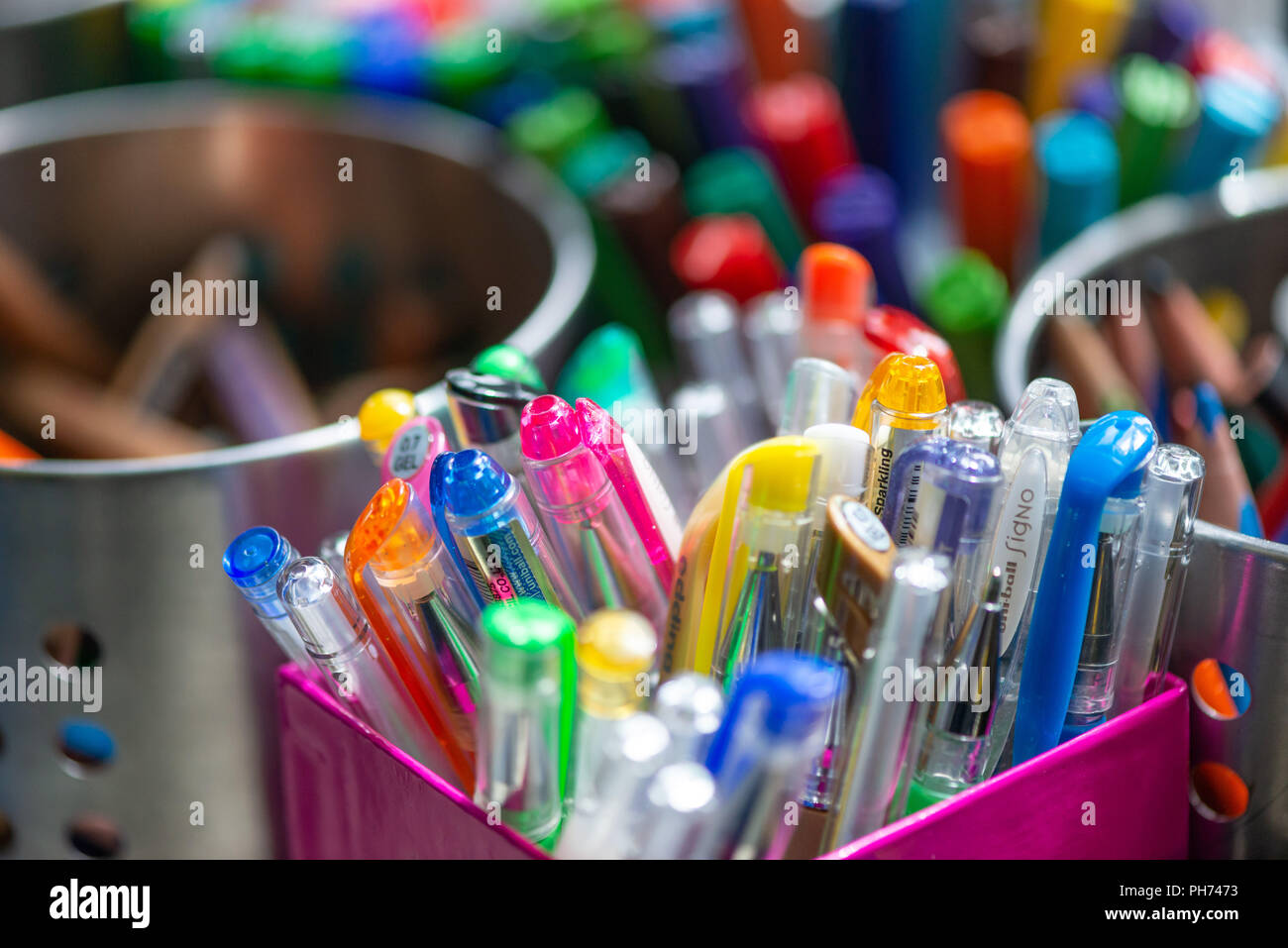 Close up image of pots of coloured pens and crayons in a school art classroom Stock Photo