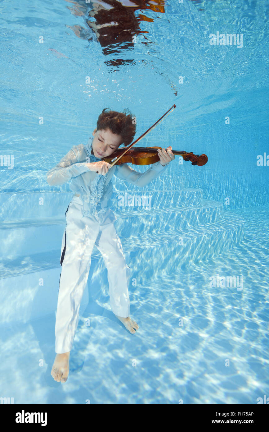 Boy playing the violin underwater Stock Photo