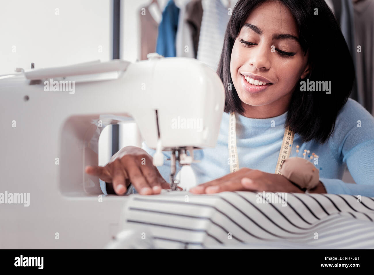 Professional young designer sewing stylish dress Stock Photo