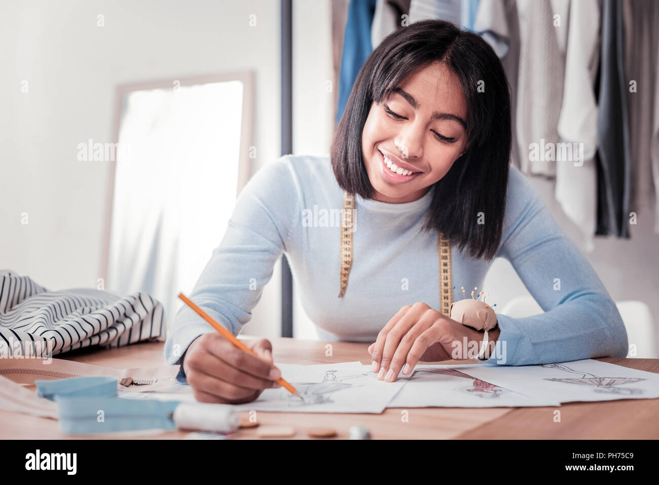 Portrait of charming dressmaker creating sketches Stock Photo
