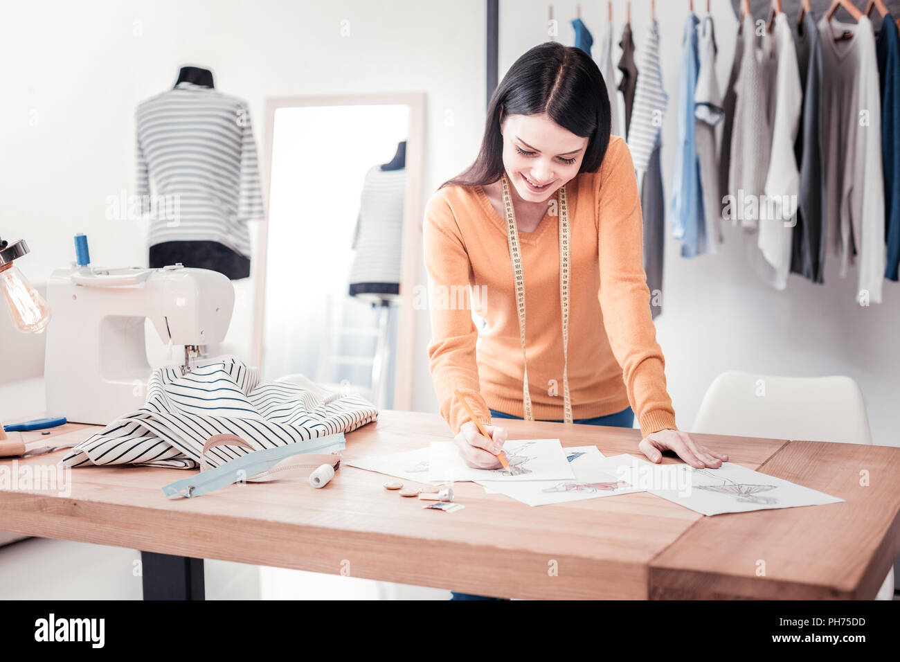 Concentrated designer creating new drafts with clothes Stock Photo - Alamy