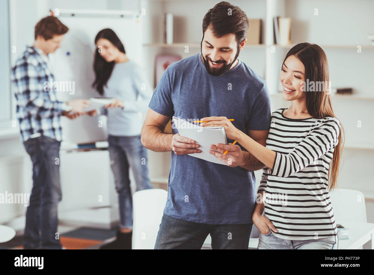 Positive young people looking at their notes Stock Photo - Alamy