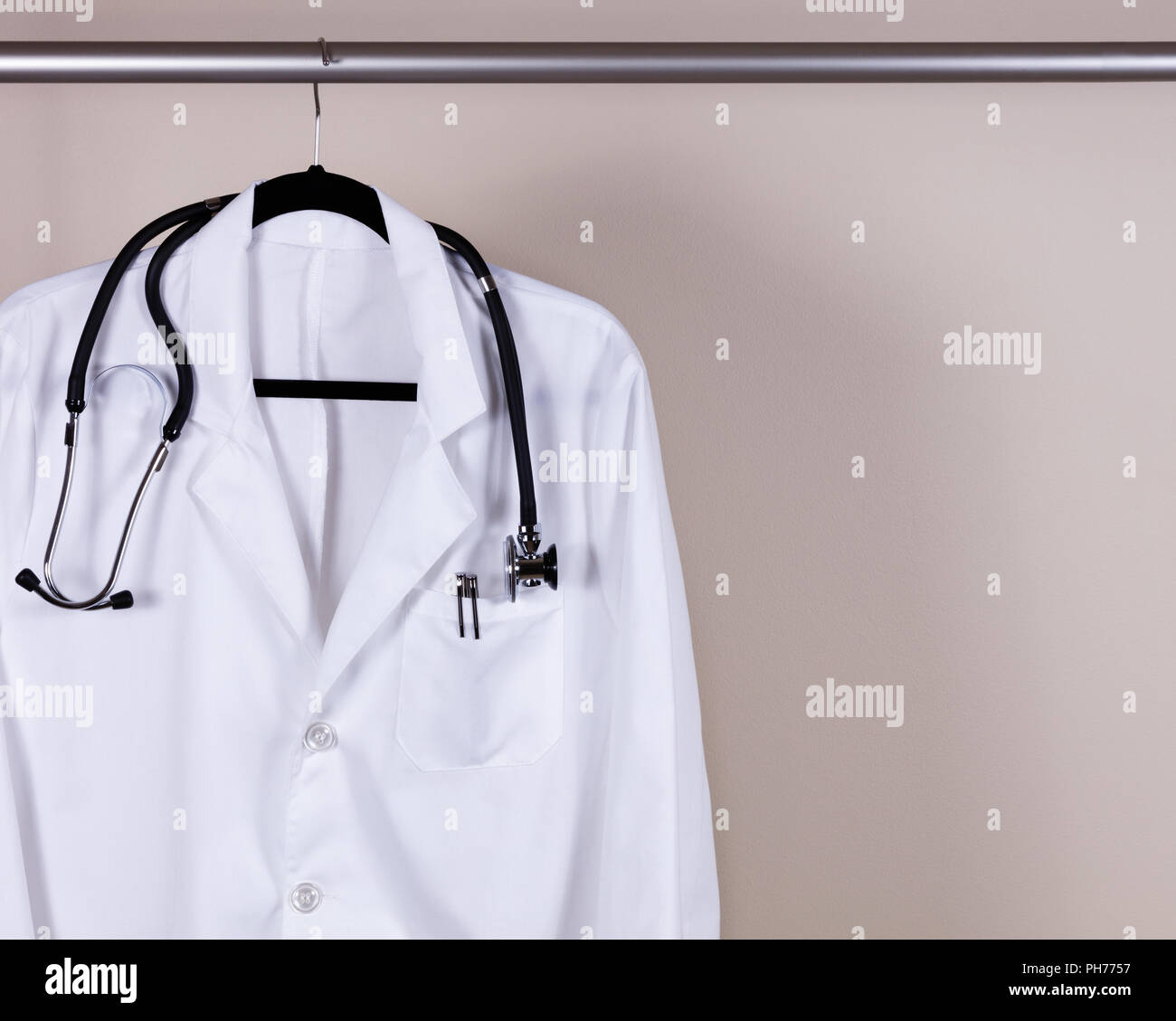 Medical white consultation coat with stethoscope and pens on hanger Stock Photo