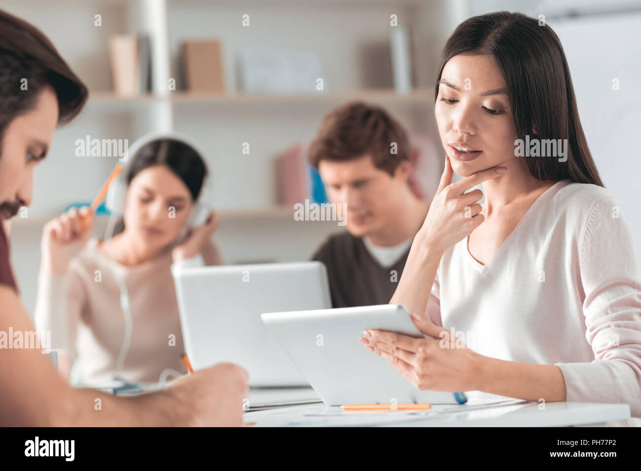 Thoughtful Asian woman touching her chin Stock Photo - Alamy