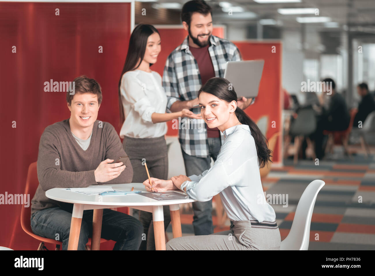 Nice young students sitting at table Stock Photo