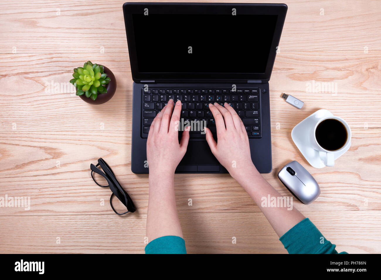 Office desktop setup with female hands working on laptop keyboard Stock Photo