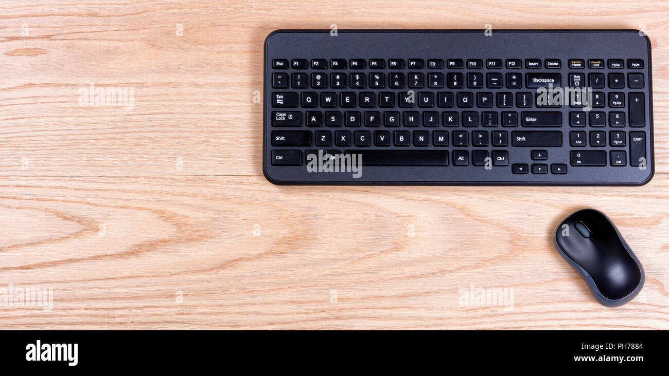 Clean and organized red oak desktop with keyboard and mouse Stock Photo