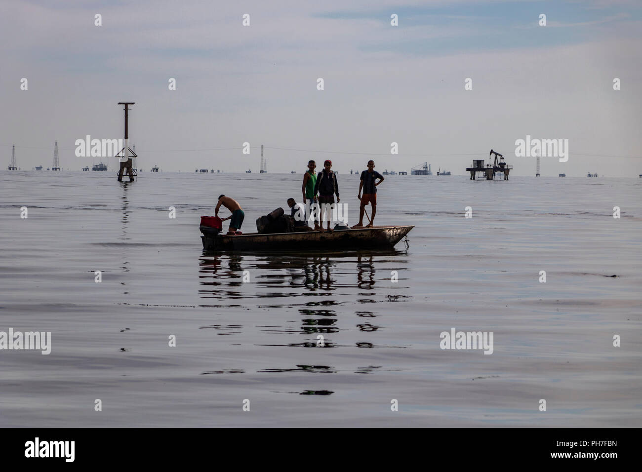 17 August 2018, Venezuela, Maracaibo: Young fishermen go by motorboat on Lake Maracaibo. In the oil-polluted lake they work as fishermen. Underneath the lake are large deposits from which the state-owned Venezuelan company PDVSA produces oil and gas. Oil pipelines are already leaking there. However, the pollution of the lake seems to have become chronic. There are hardly any official figures on this, given the situation, which is strictly controlled by the national regime. Venezuela - once the richest country in South America and blessed with the world's largest oil reserves - has been increas Stock Photo