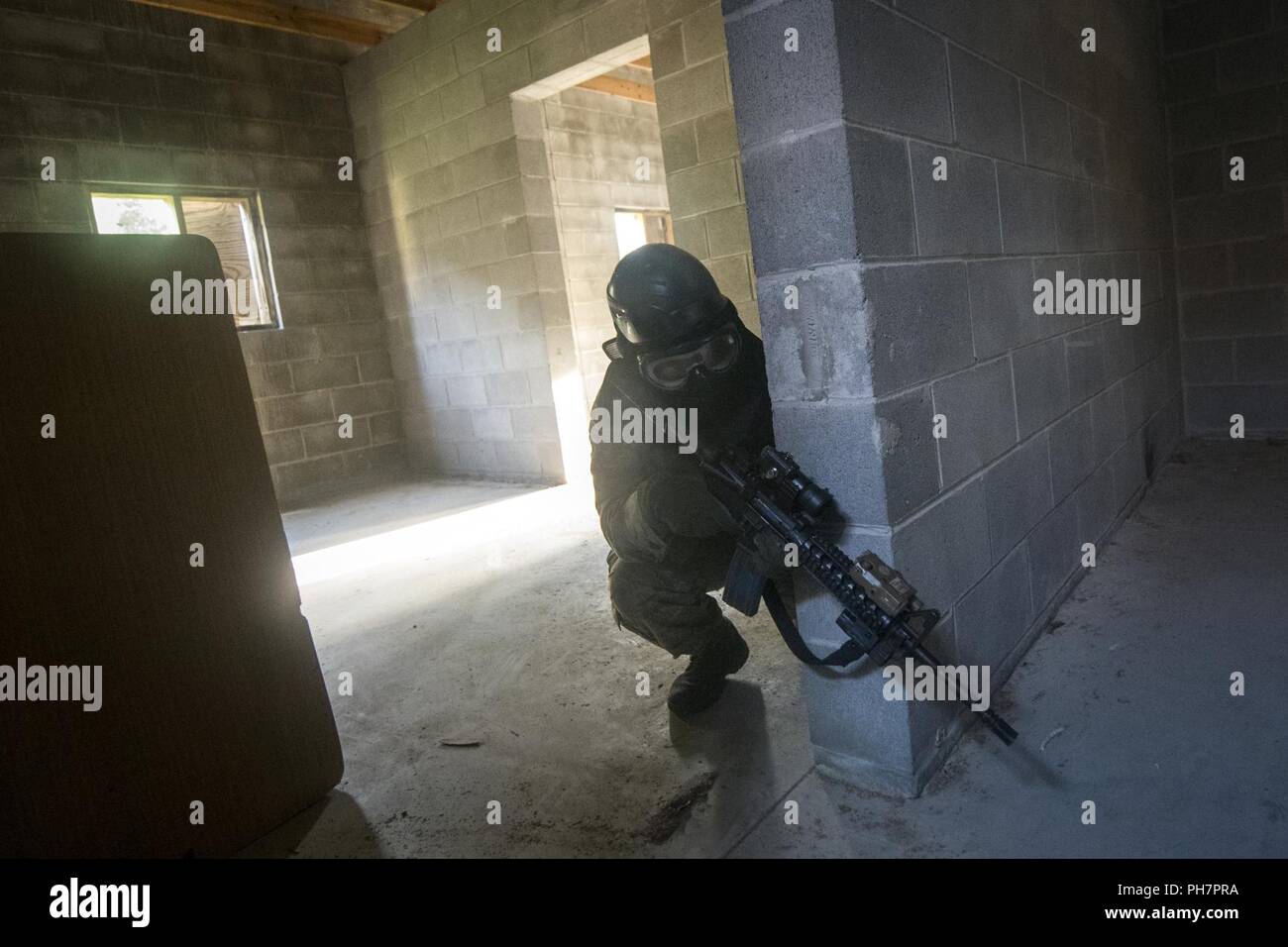 An Airman from the 23d Security Forces Squadron (SFS) scans his perimeter during a Force on Force training scenario, June 29, 2018, at Moody Air Force Base, Ga. This training was held to ensure SFS Airmen are proficient in various tactics and procedures such as: building clear out, team movements, hostage rescue and properly applying cover fire. The scenario required Airmen to maneuver through multiple buildings to rescue a simulated victim guarded by opposing forces. Stock Photo