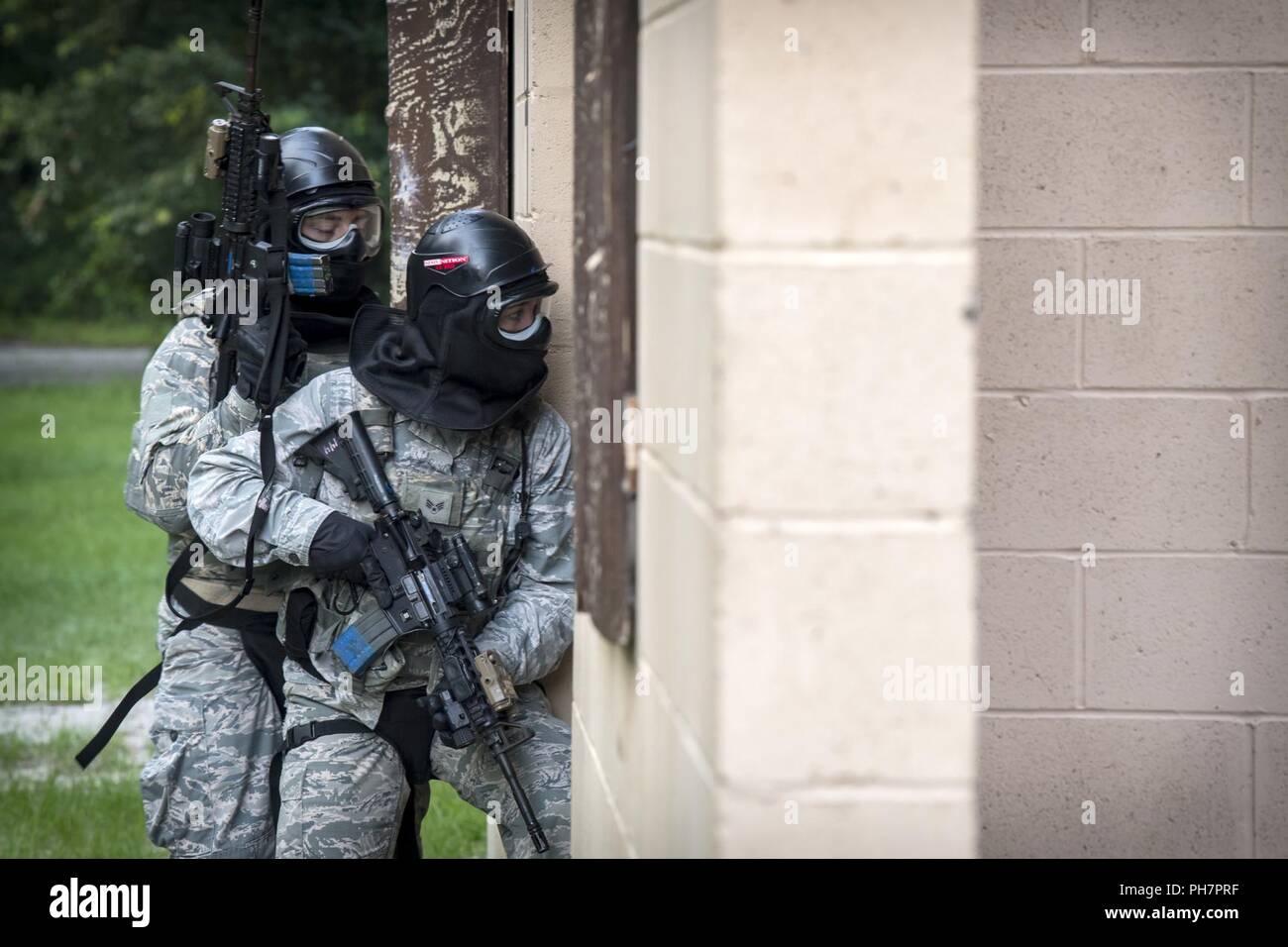 Airmen from the 23d Security Forces Squadron (SFS) enter a building during a Force on Force training scenario, June 29, 2018, at Moody Air Force Base, Ga. This training was held to ensure SFS Airmen are proficient in various tactics and procedures such as: building clear out, team movements, hostage rescue and properly applying cover fire. The scenario required Airmen to maneuver through multiple buildings to rescue a simulated victim guarded by opposing forces. Stock Photo