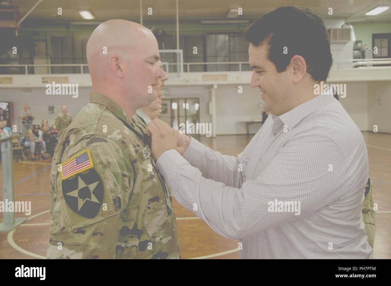 Sgt. Richard Schutt, Medical Section, Headquarters and Headquarters Battery, 2nd Battalion, 146th Field Artillery Regiment, 81st Stryker Brigade Combat Team, receives an Army Achievement Medal from Ayoub Soulami, the father of the a little girl’s life that his team helped to save, June 30, 2018, at the National Guard Armory, Olympia, Wash. The medical team saved the girl by administering cardiopulmonary resuscitation when her medical team made happened upon the emergency during a routine fuel stop, on April 6, 2018. Stock Photo