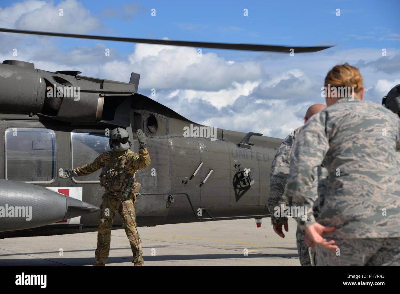 U.S. Army Sgt. Andrew Greenfield, helicopter mechanic with the 1st  Battalion, 52nd Aviation Regiment, supervises a medivac drill during joint  force Air Force and Army medical training at Fort Wainwright, Alaska June