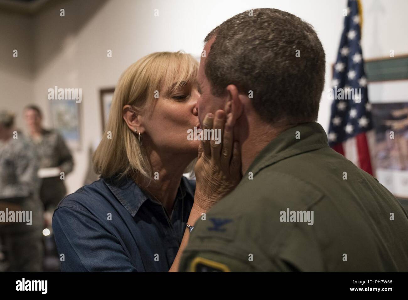 Martha Brett kisses her husband, Col. Jeffrey Brett, during a retirement ceremony at the Museum of Aviation, Robins Air Force Base, Ga., June 22, 2018. Brett is a former commander of the 413th Flight Test Group who served in the position from March 2015 to June 2016. His most recent assignment was at Stuttgart, Germany, as a battle watch captain for the U.S. European Command. Stock Photo