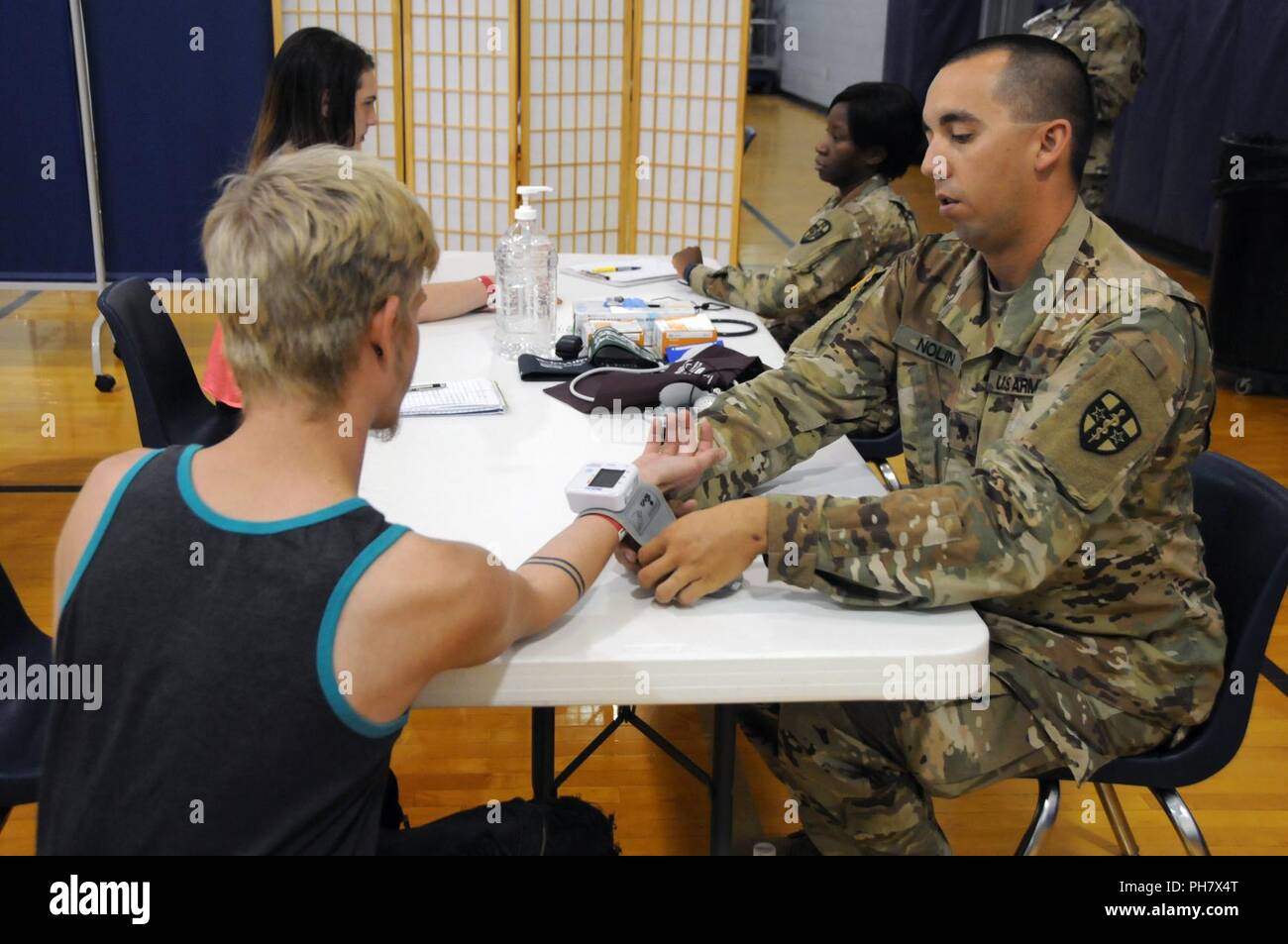 Spc. Travis Nolin (right) and Sgt. Imelda Daria (left), combat medics assigned to 7215th Medical Support Unit based in St. Louis, Missouri, take vitals for residence during Innovative Readiness Training (IRT) exercise Southeast Illinois Wellness.   Services provided by military personnel are done through the Department of Defense’s Innovative Readiness Training, a civil-military program that builds mutually beneficial partnerships between U.S. communities and the DoD. The missions selected meet training & readiness requirements for Army Reserve service members while integrating them as a joint Stock Photo