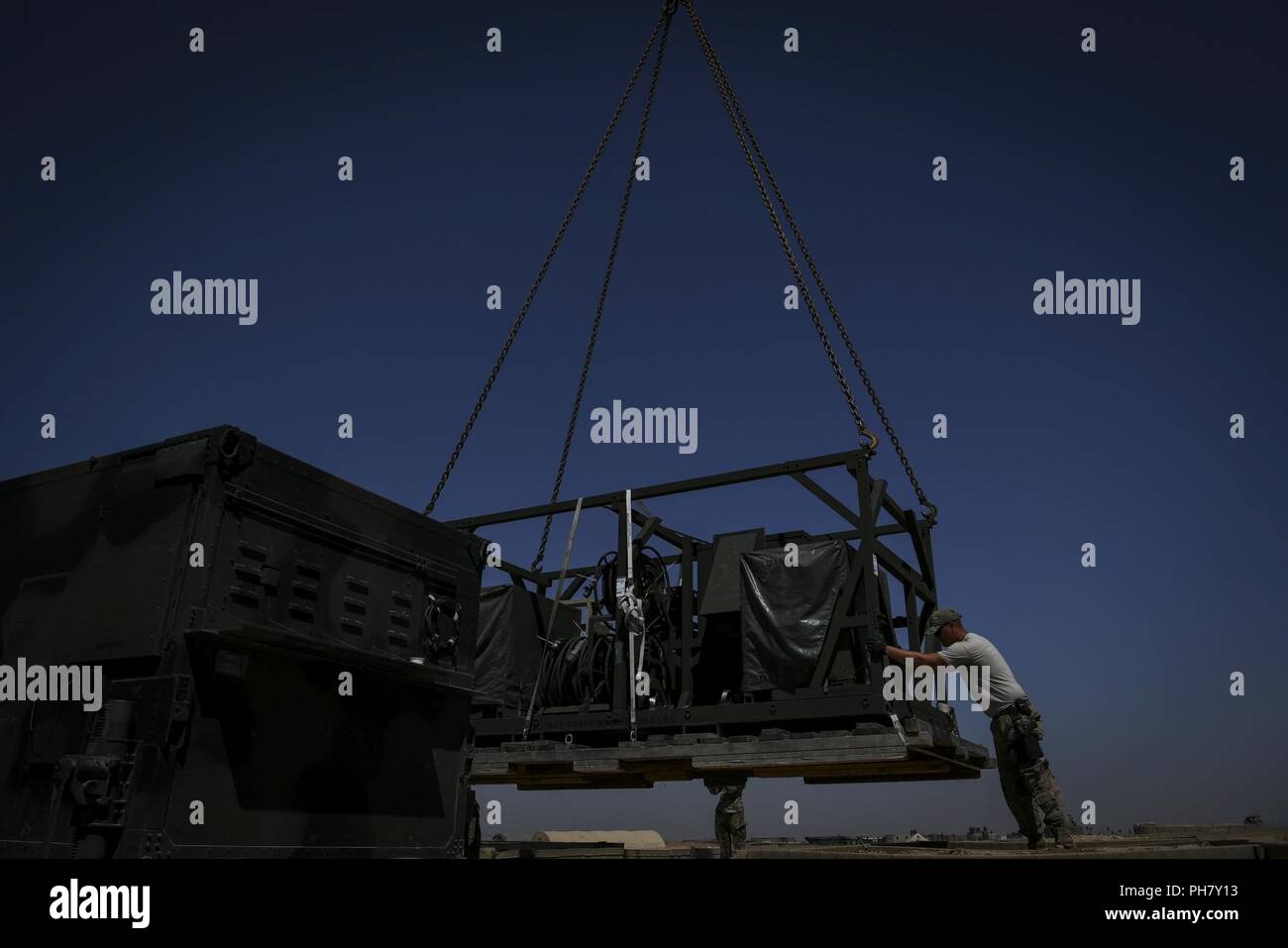 U.S. Air Force Airmen assigned to the 727th Expeditionary Air Control Squadron (EACS) guide radar equipment into position at a Coalition airfield in Northeast Syria, June 27, 2018. The 727th EACS, known as 'Kingpin,' provides air command and control capabilities of joint air operations in the U.S. Air Forces Central Command area of responsibility. Stock Photo