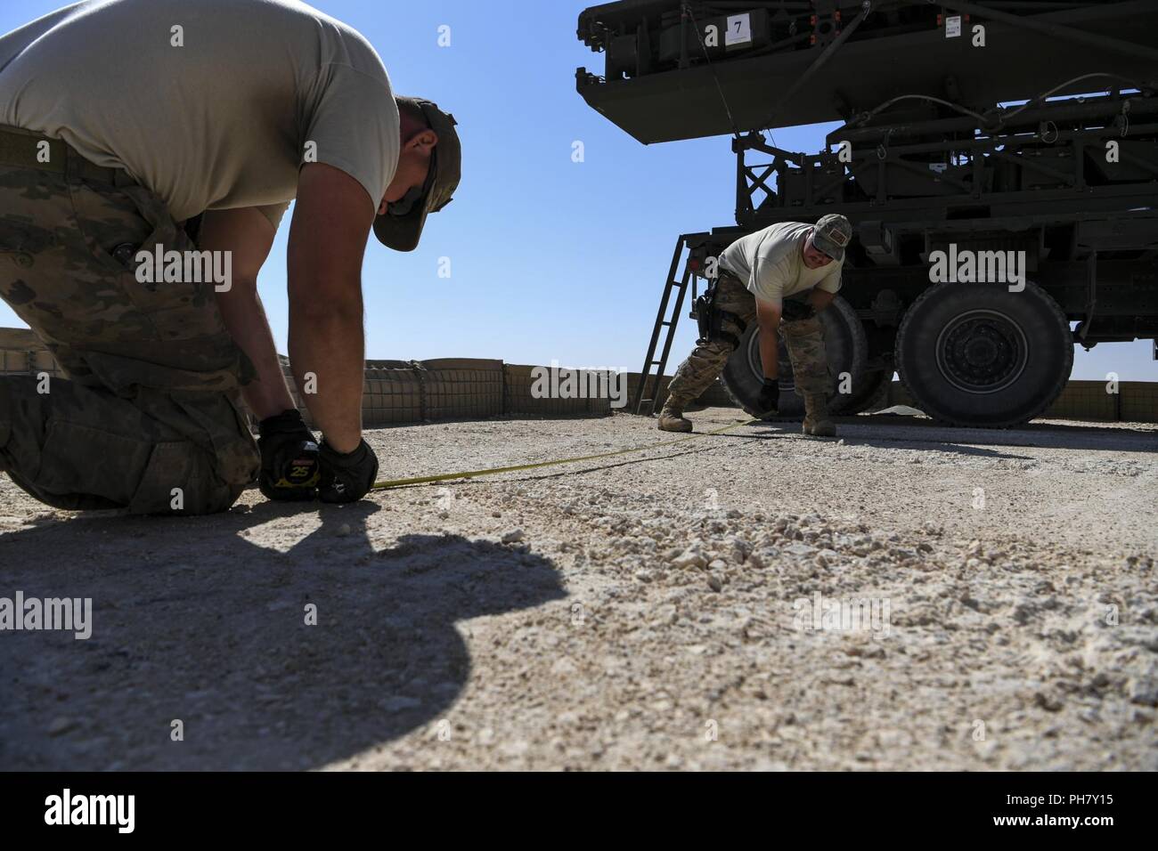 U.S. Air Force Airmen assigned to the 727th Expeditionary Air Control Squadron (EACS) measure out a placement for radar equipment at a Coalition airfield in Northeast Syria, June 27, 2018. Known as 'Kingpin,' the 727th EACS is comprised of 14 career fields that are responsible for monitoring and providing vital air picture information to ensure the successful completion of assigned missions in the theater. Stock Photo