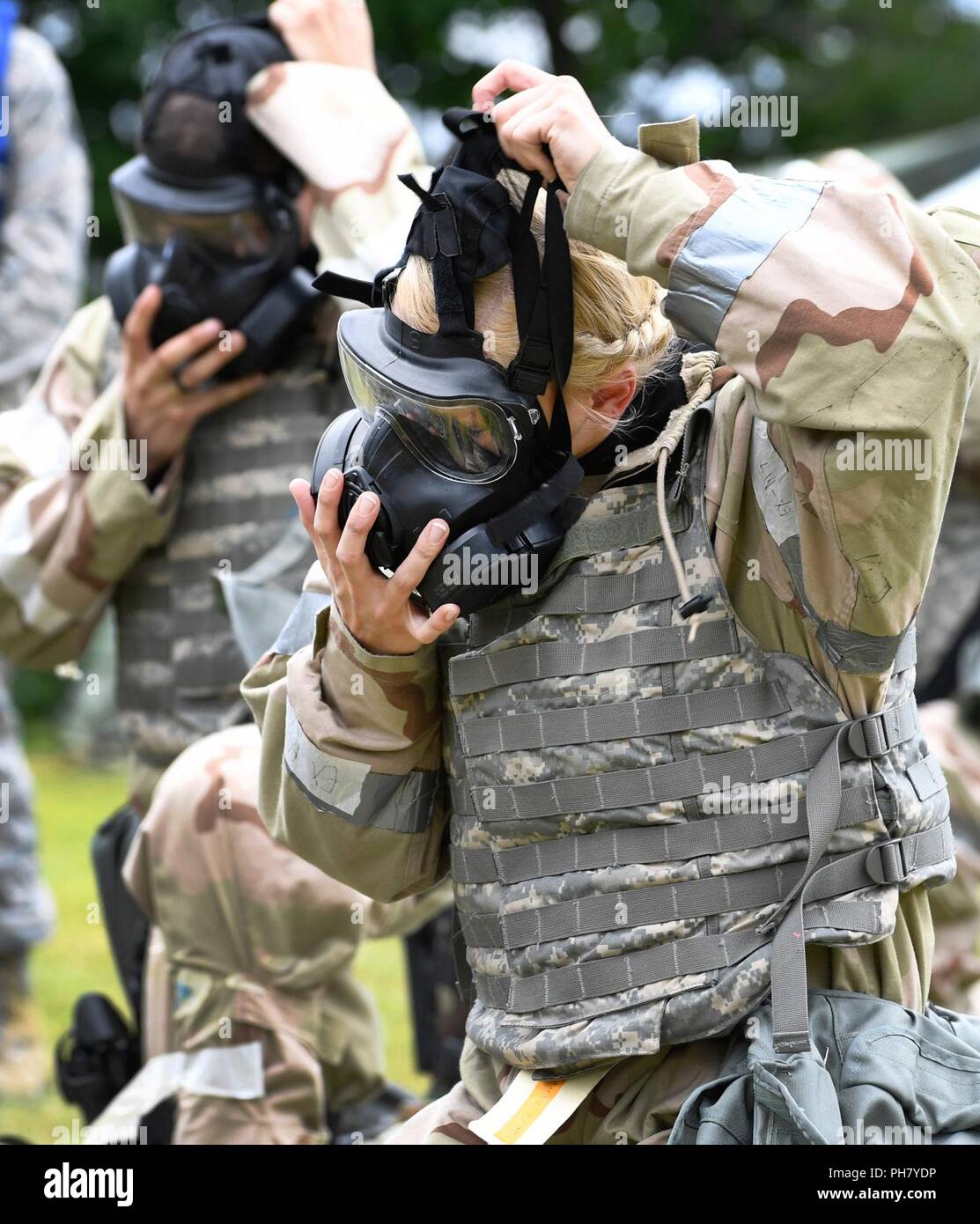 Airman 1st Class Valerie Kelley, 66th Medical Squadron aerospace medical technician, puts on a gas mask during an ability to survive and operate, or ATSO, training session at Hanscom Air Force Base, Mass., June 14. The training prepares Airmen to operate in a deployed environment. Stock Photo