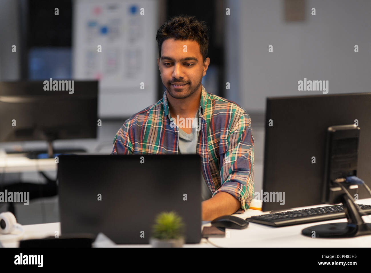 creative man with laptop working at night office Stock Photo - Alamy