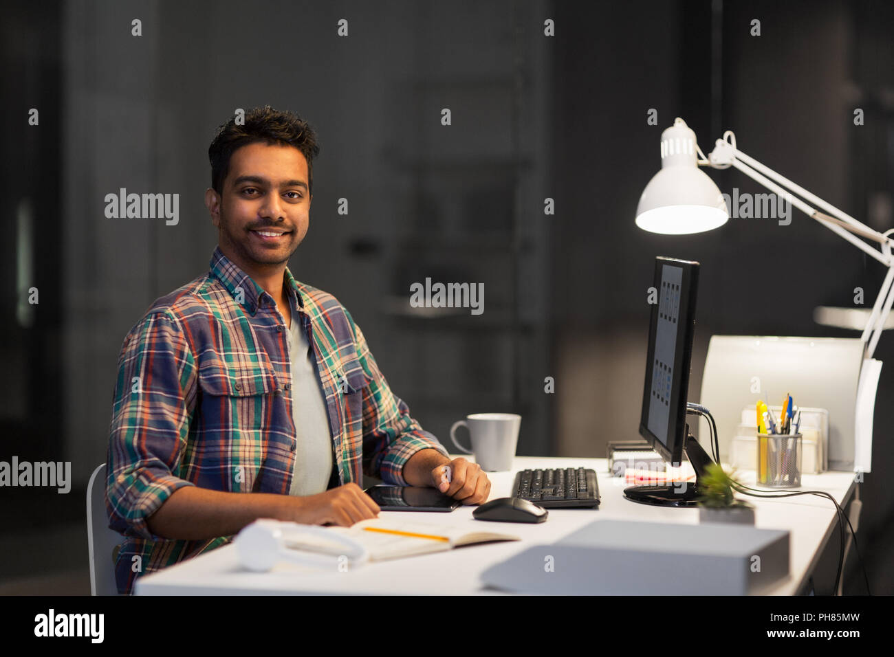 designer with computer working at night office Stock Photo