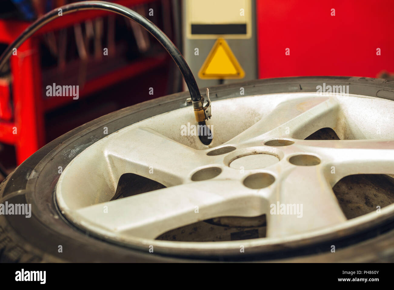 checking air pressure and filling air in the tires close up in a garage