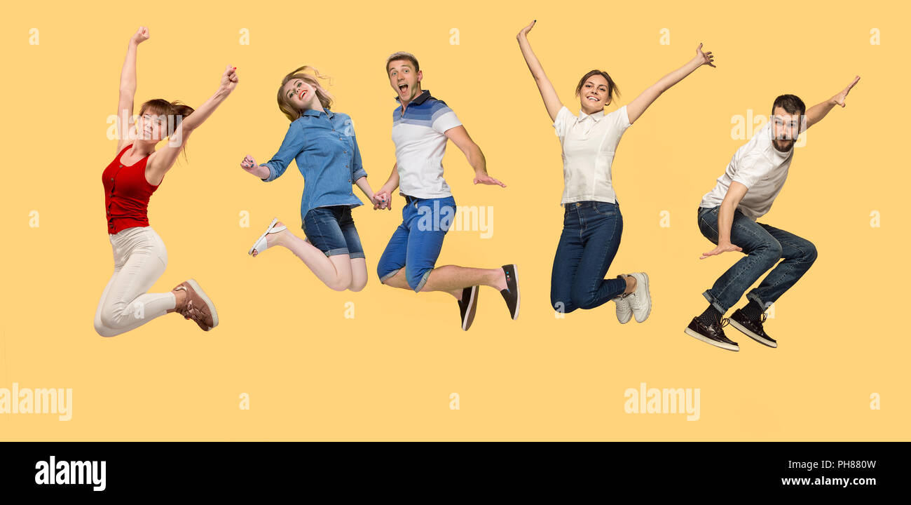 People Springing Forward Freedom in moving. Mid-air shot of pretty happy young man and women ...