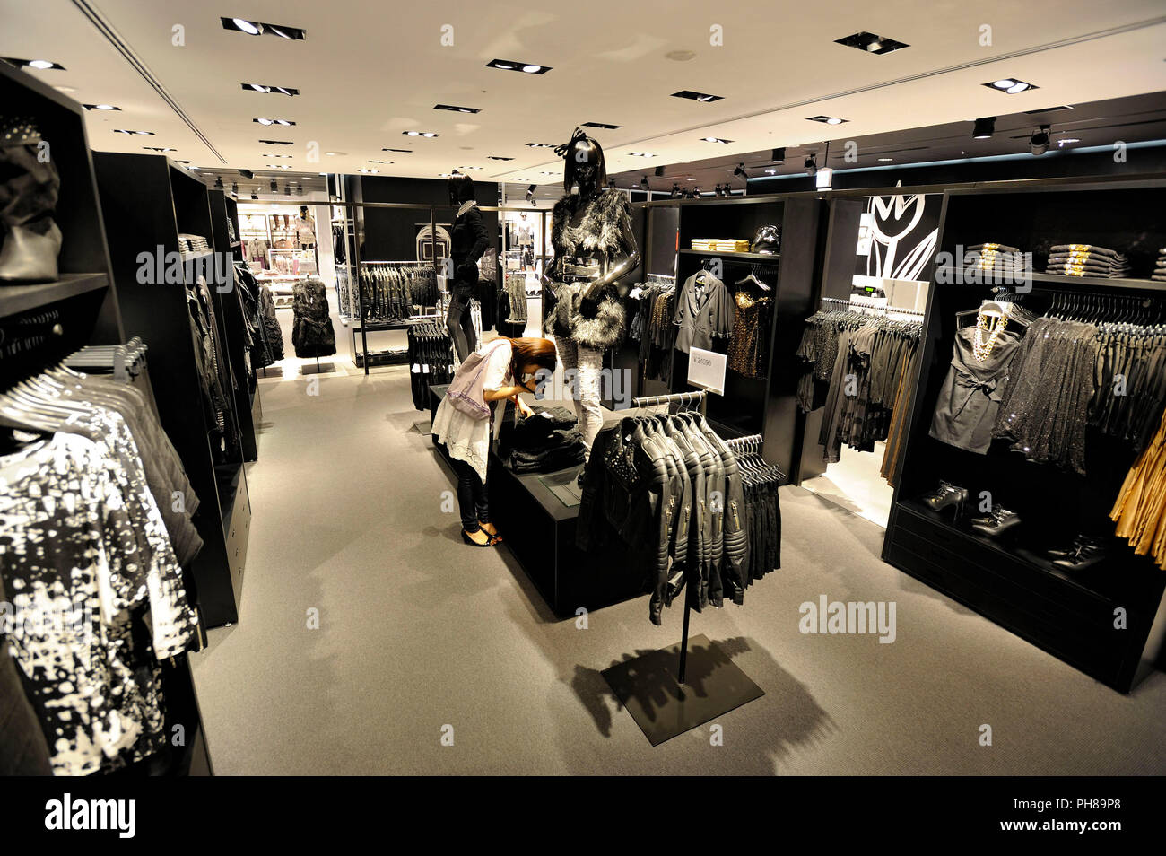 A member of the media takes a photo of women's clothing displayed at H&M  Hennes & Mauritz Japan KK's soon-to-open flagship store in the Shibuya  distr Stock Photo - Alamy