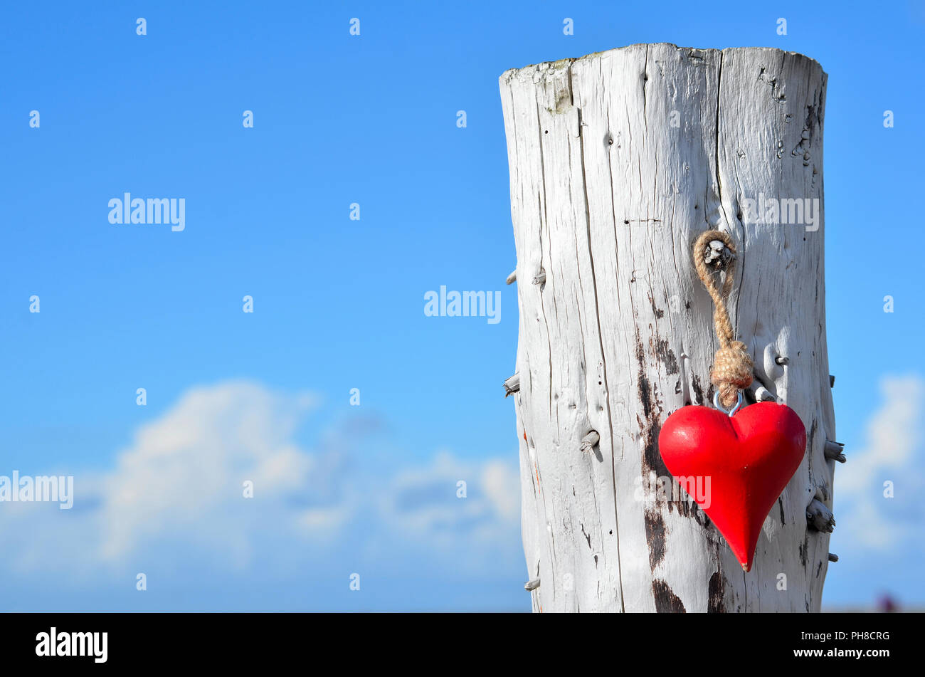 A red wooden heart on the beach Stock Photo