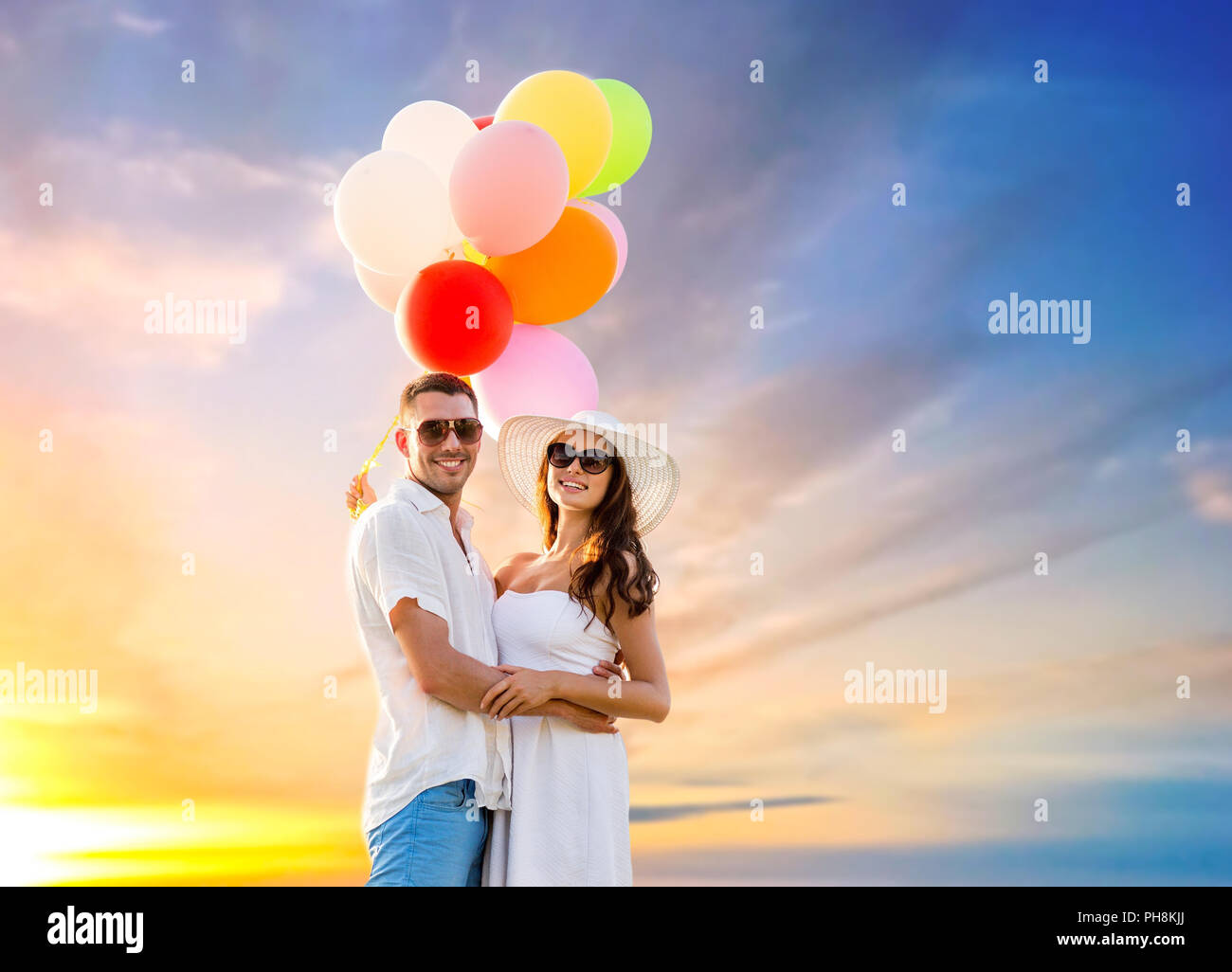 happy couple with balloons over sunset sky Stock Photo - Alamy