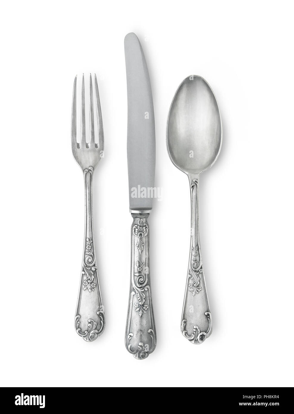 Silverware set against white background with a soft shadow. Really silver pieces with ancient marks and texture. Clipping path Stock Photo