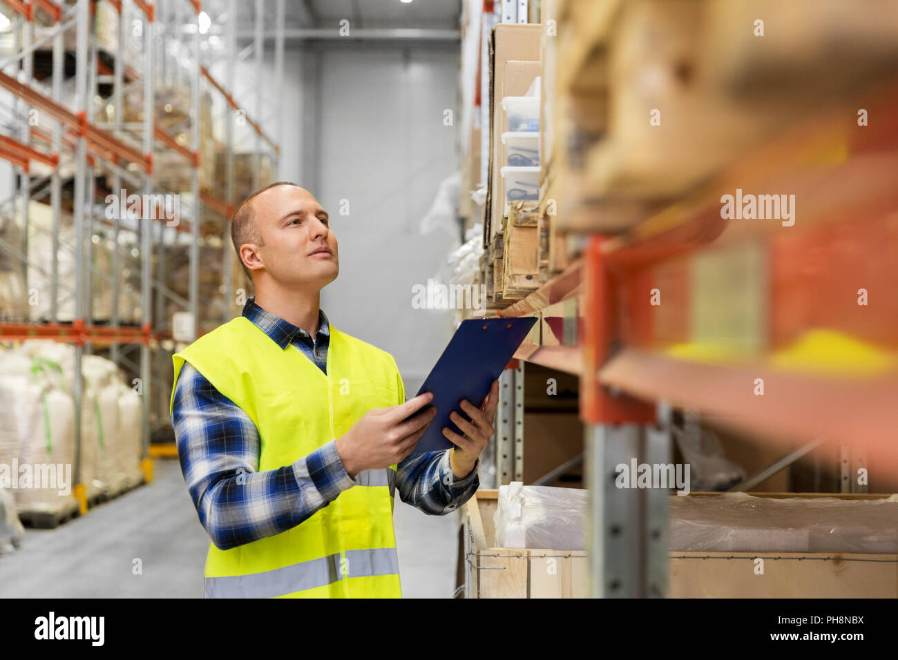 warehouse worker with clipboard in safety vest Stock Photo