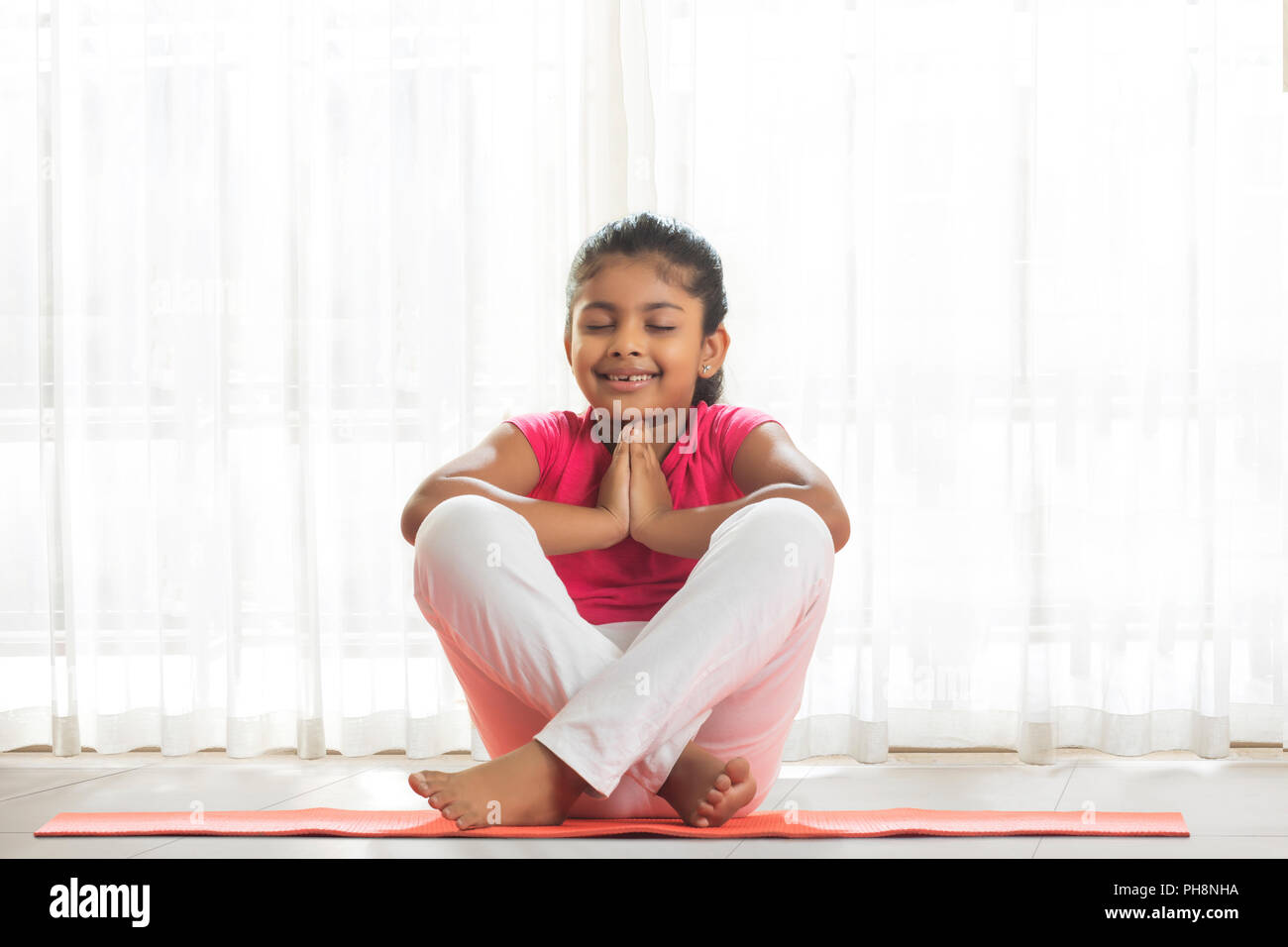 Little girl doing yoga at home Stock Photo