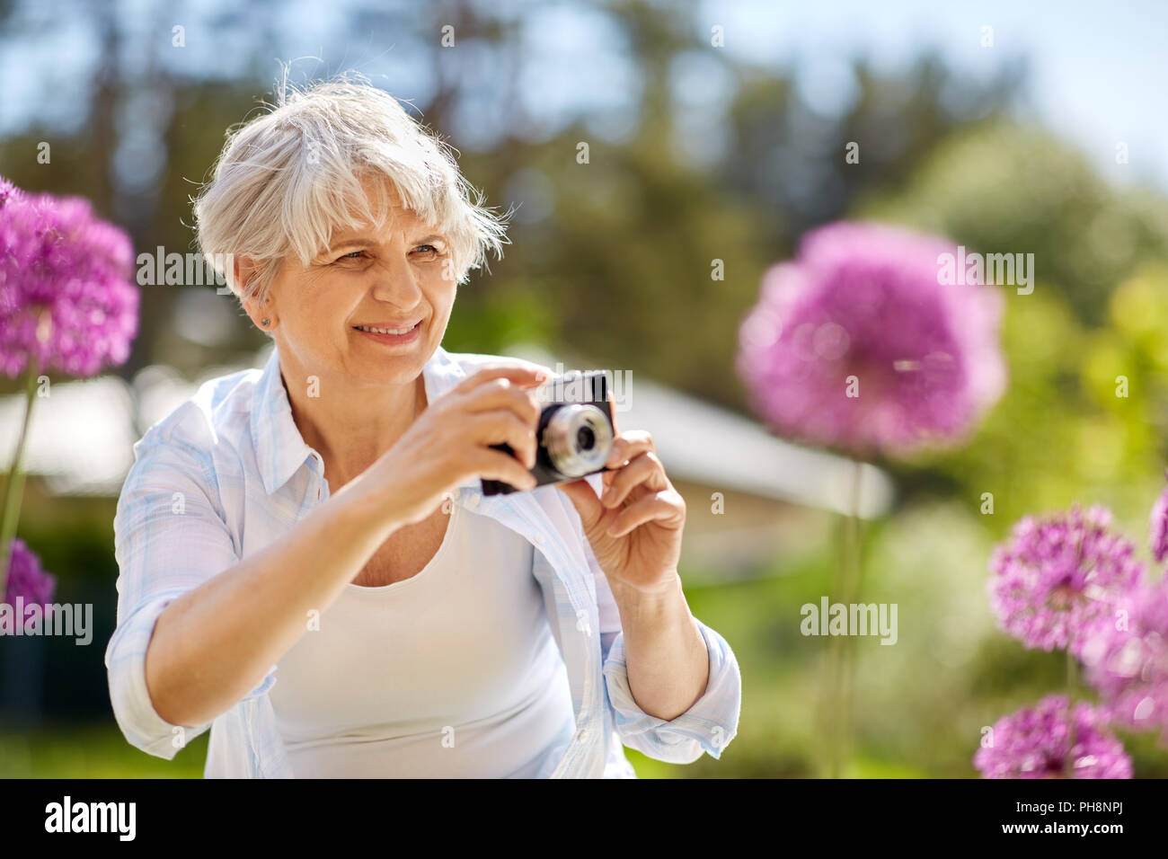 senior woman with camera photographing flowers Stock Photo - Alamy