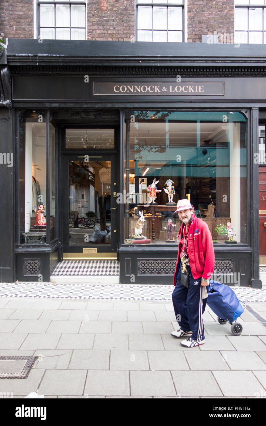 An elderly man pulling a shopping trolley outside Connock & Lockie