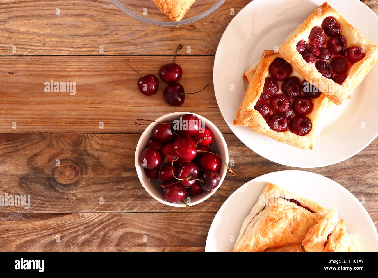 Freshly baked puff pastry squares with cherries, flat lay Stock Photo