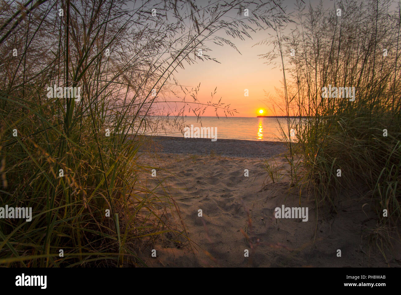 Sunrise Beach Scenic Seascape. Coastal scenic sunrise beach on the rocky shore of Lake Huron in Lexington, Michigan. Stock Photo