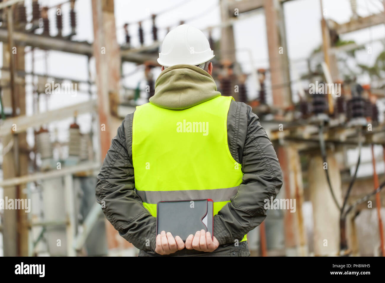 Electrician with tablet PC in electrical substatio Stock Photo