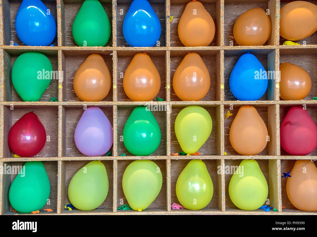 colorful inflated balloons in wooden box frame for carnival game Stock Photo