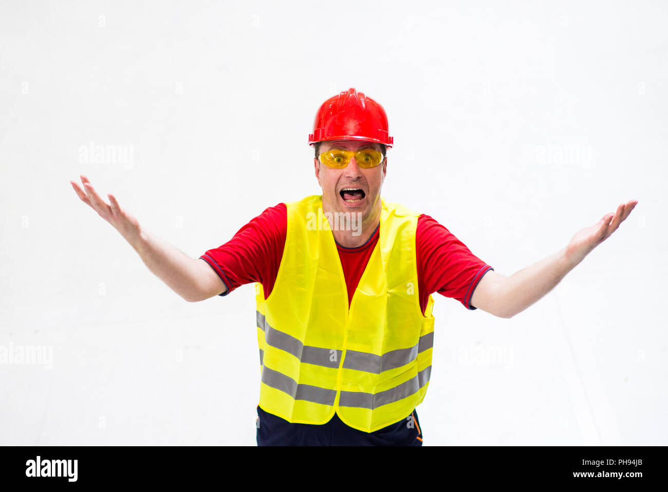 Confused factory worker expressing anger looking up in his boss with arms wide opened Stock Photo
