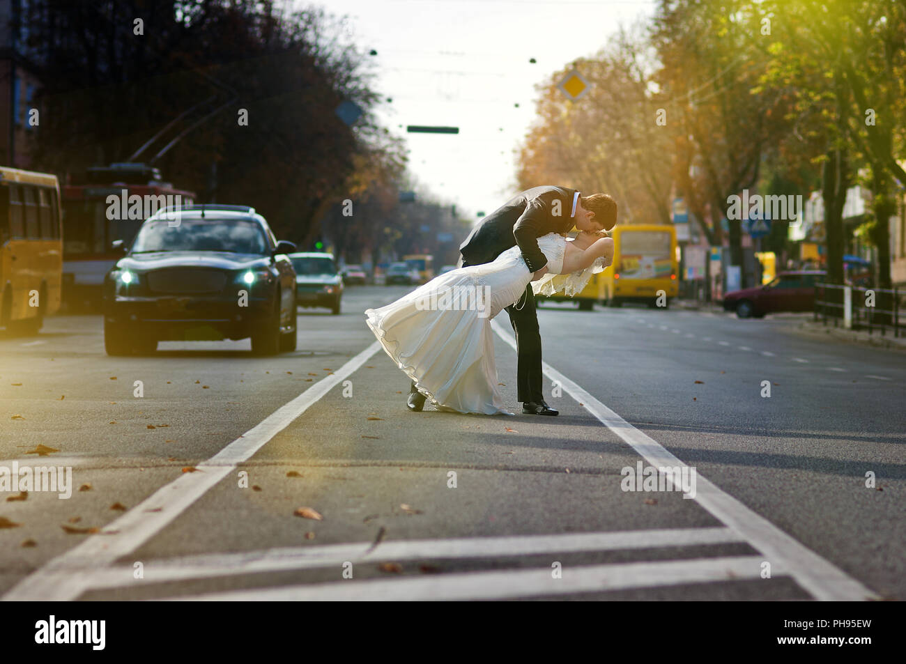 Kissing wedding couple in the middle of the road Stock Photo