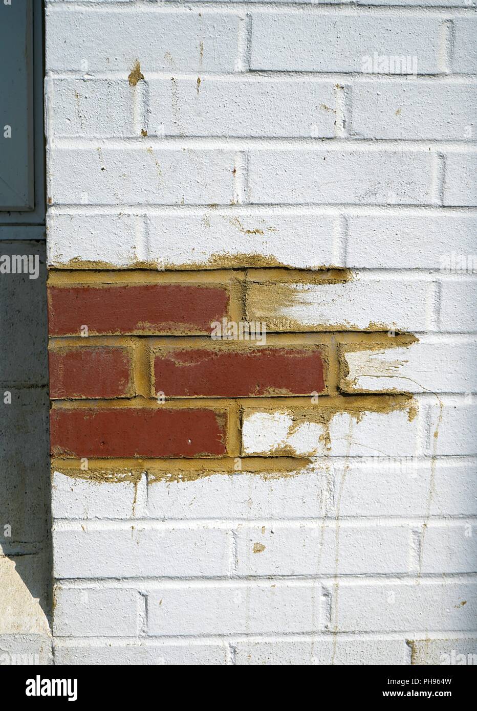 Architectural renovation Replacement masonry Red Bricks replaced in a white wall with fresh