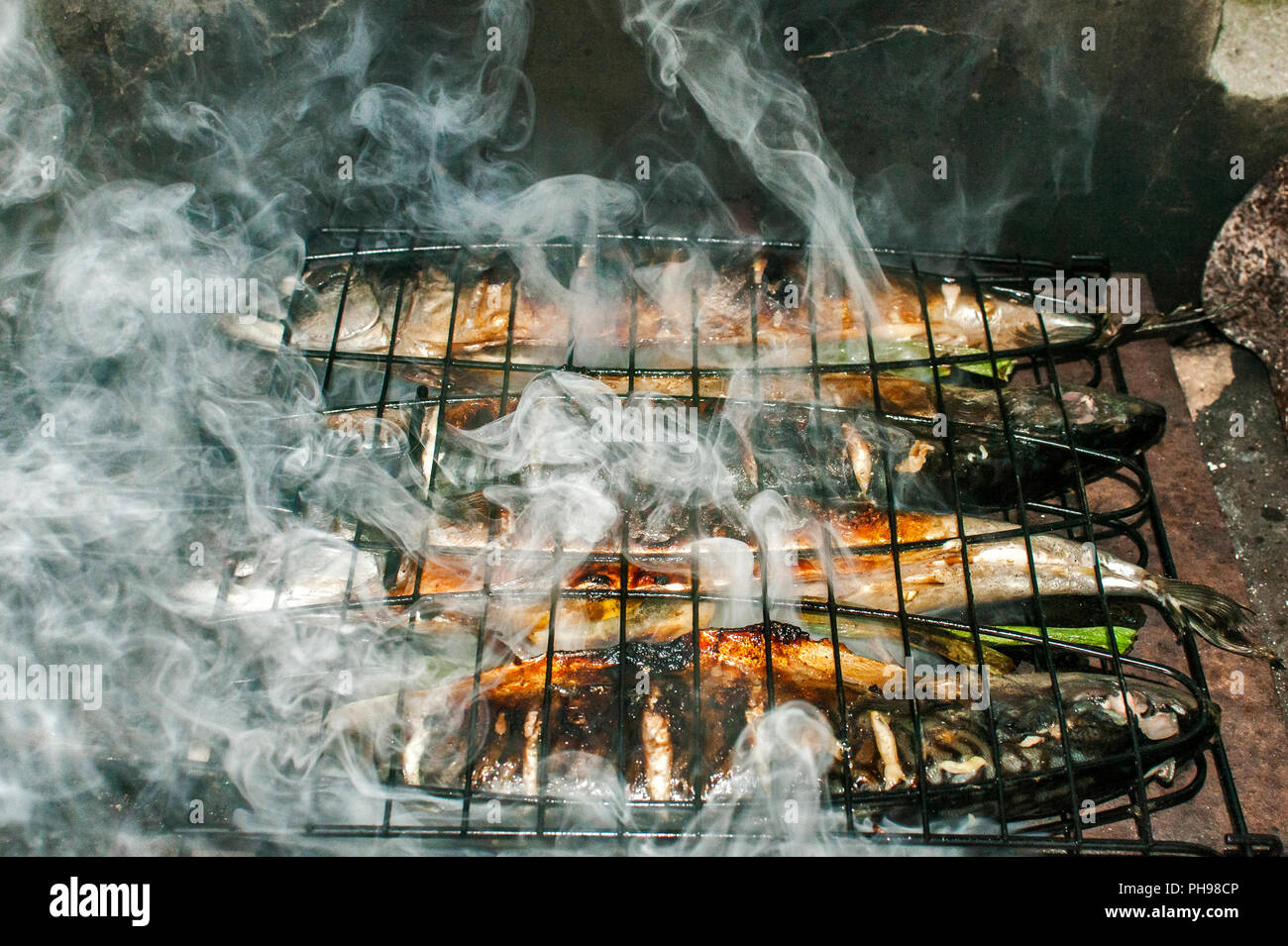 Mackerel Fish Grilled On Iron Plate In Rural House Fireplace