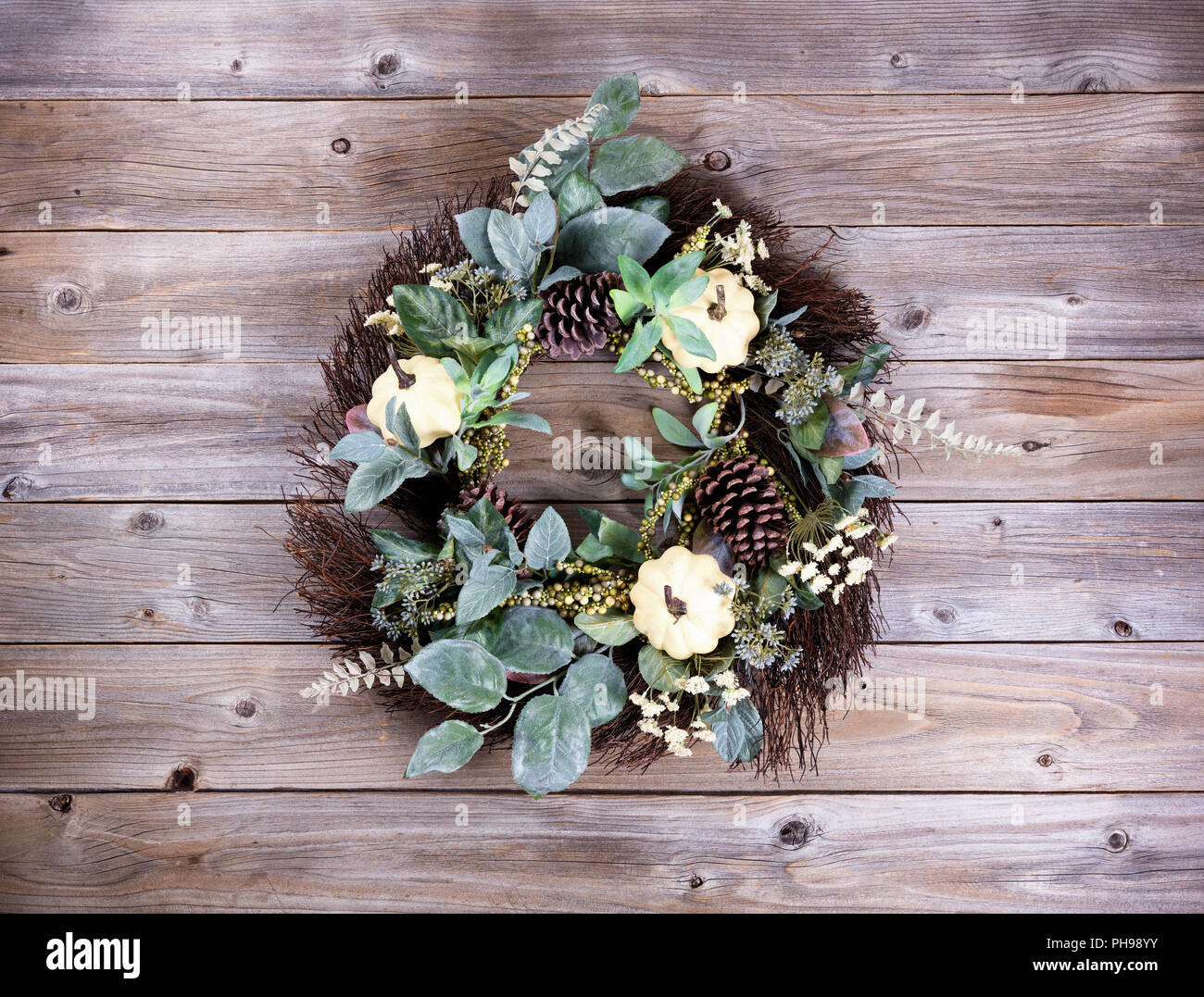 Autumn holiday wreath on rustic wooden boards Stock Photo
