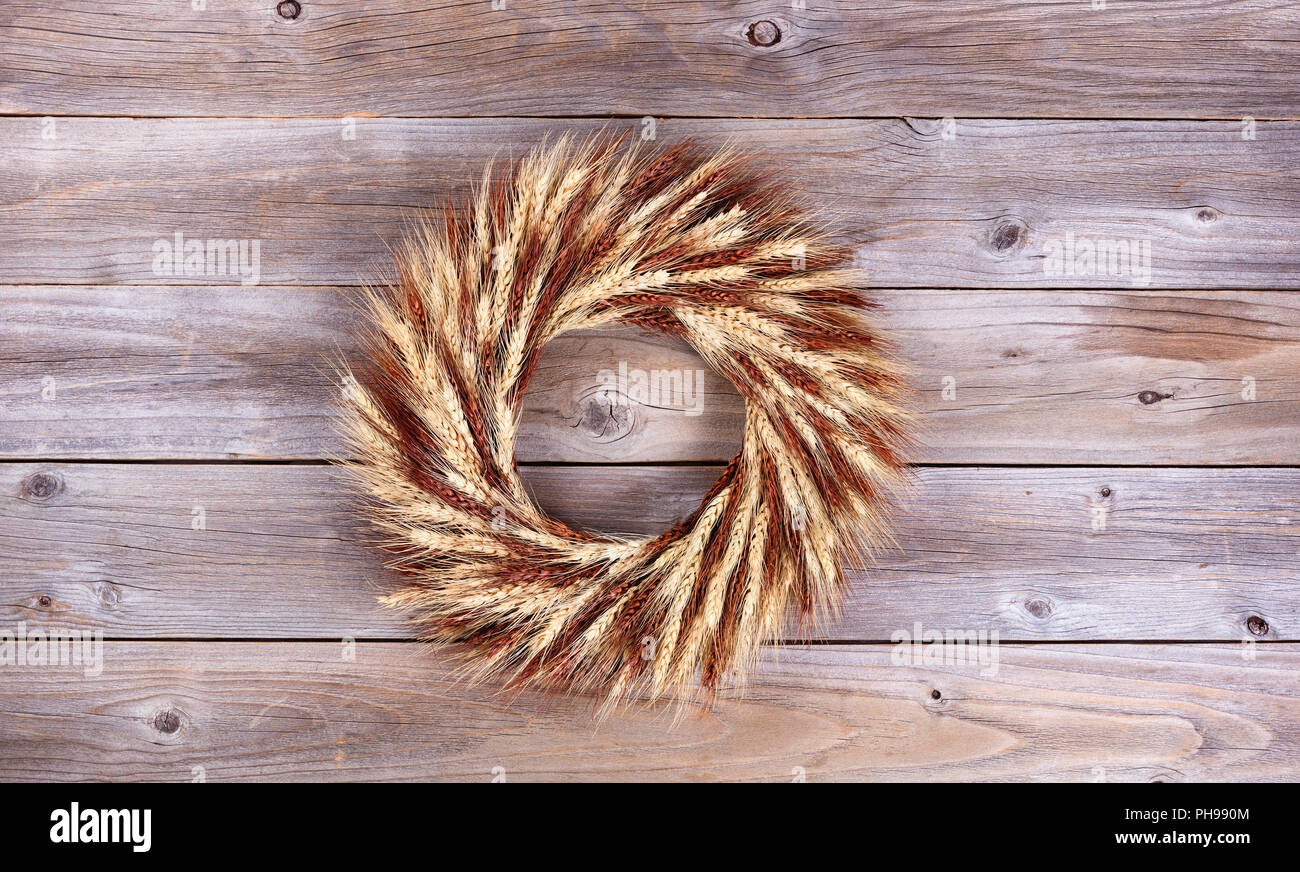 Dried wheat stalk wreath on rustic wooden boards Stock Photo