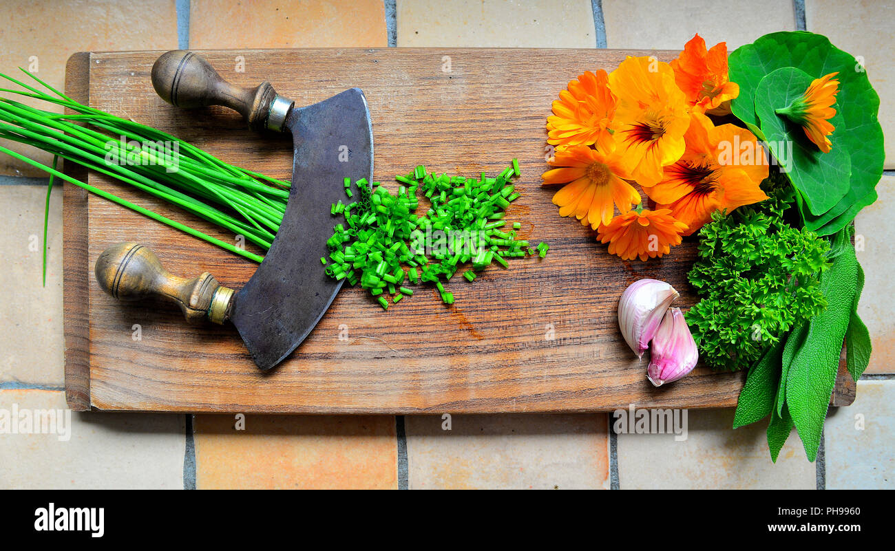 Herbs on a wooden board and knife Stock Photo - Alamy